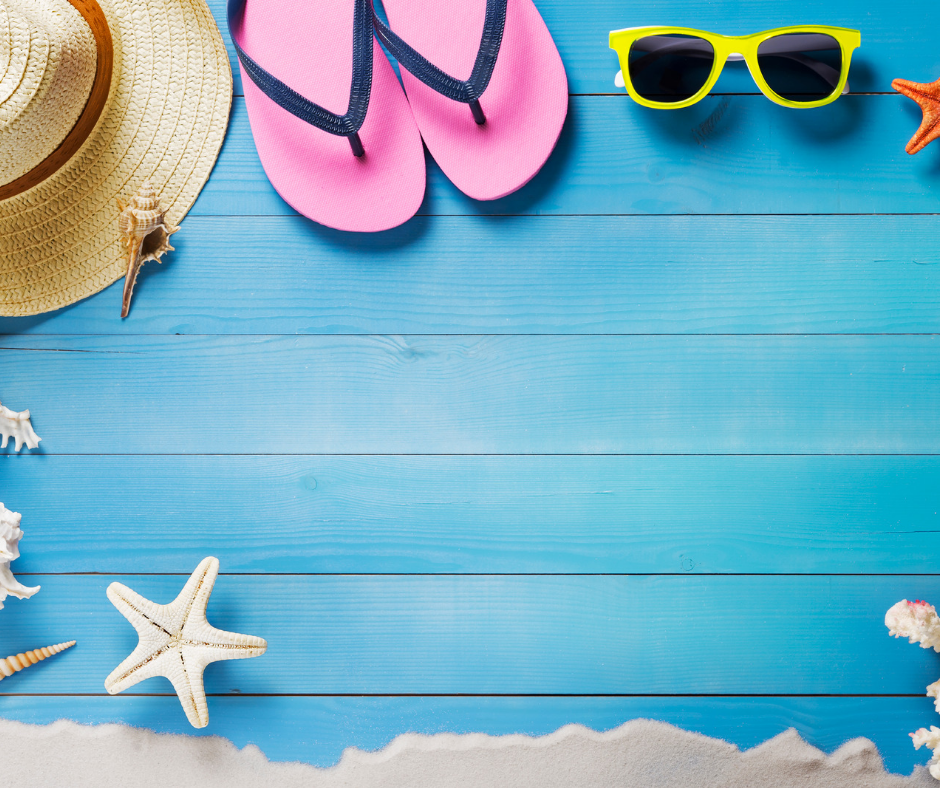 Items for a beach holiday. Hat, sunglasses and flip flops on a beach hut background. 
